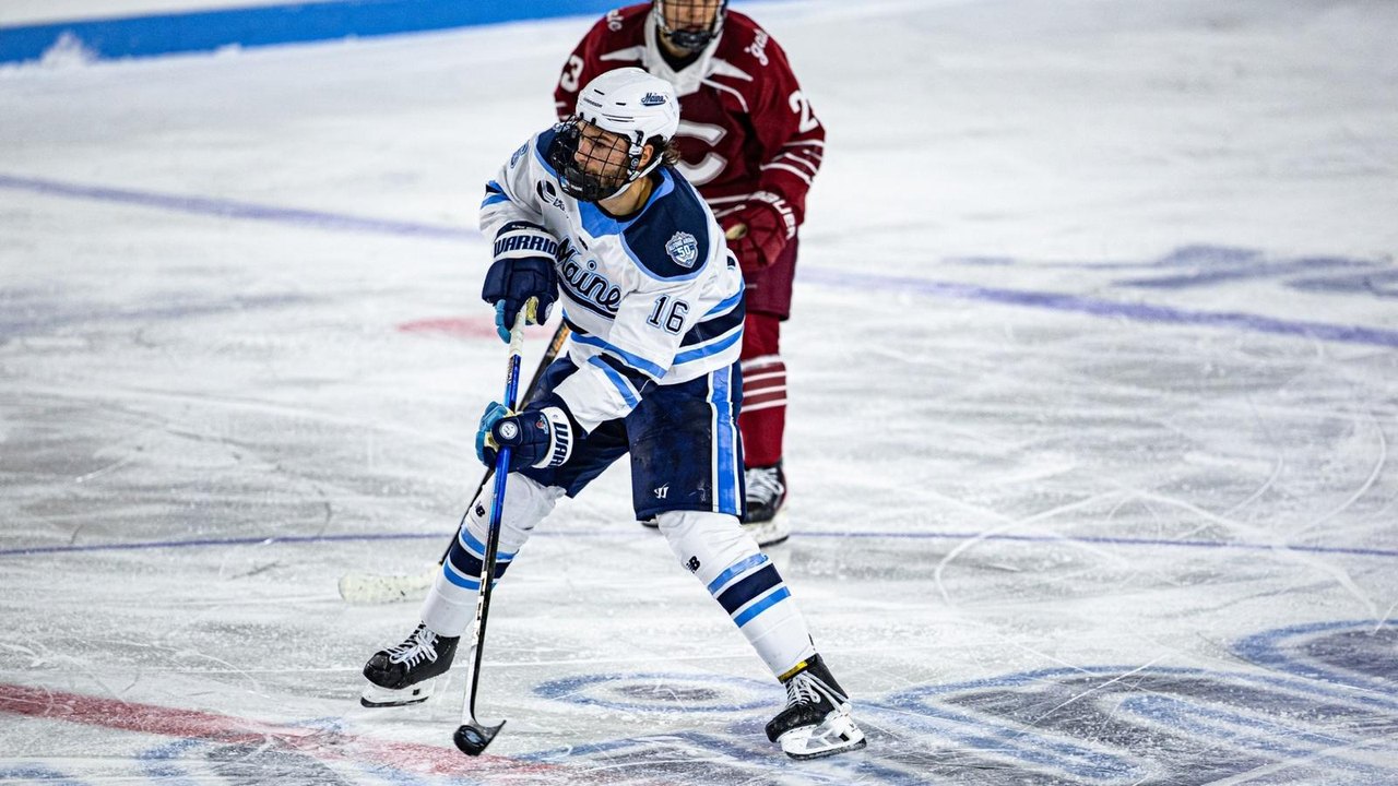 Loic Usereau controls the puck while a Colgate player follows.